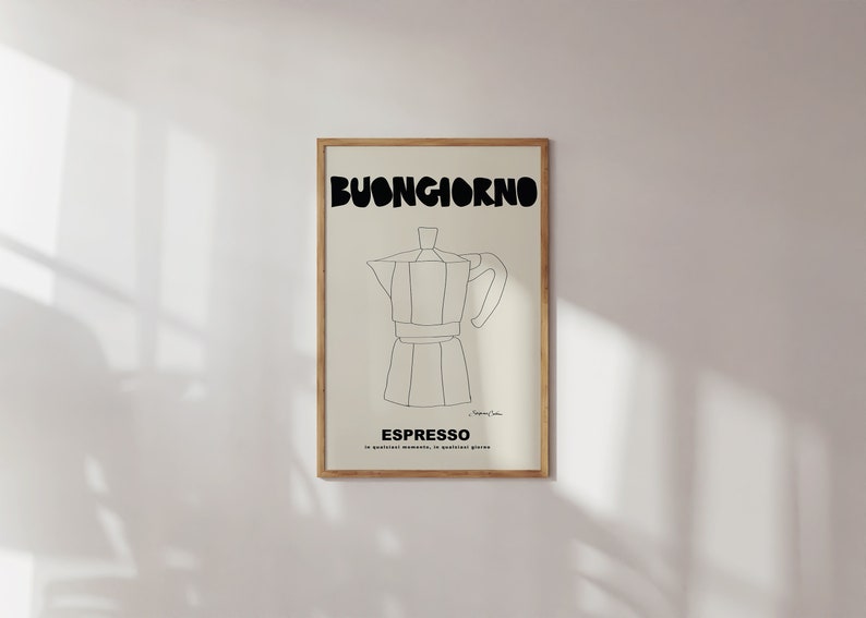 May include: A framed wall art print featuring a black line drawing of a moka pot centered on a cream background. The text BUONGIORNO appears in large black letters at the top, with ESPRESSO and smaller Italian text printed below the coffee maker.