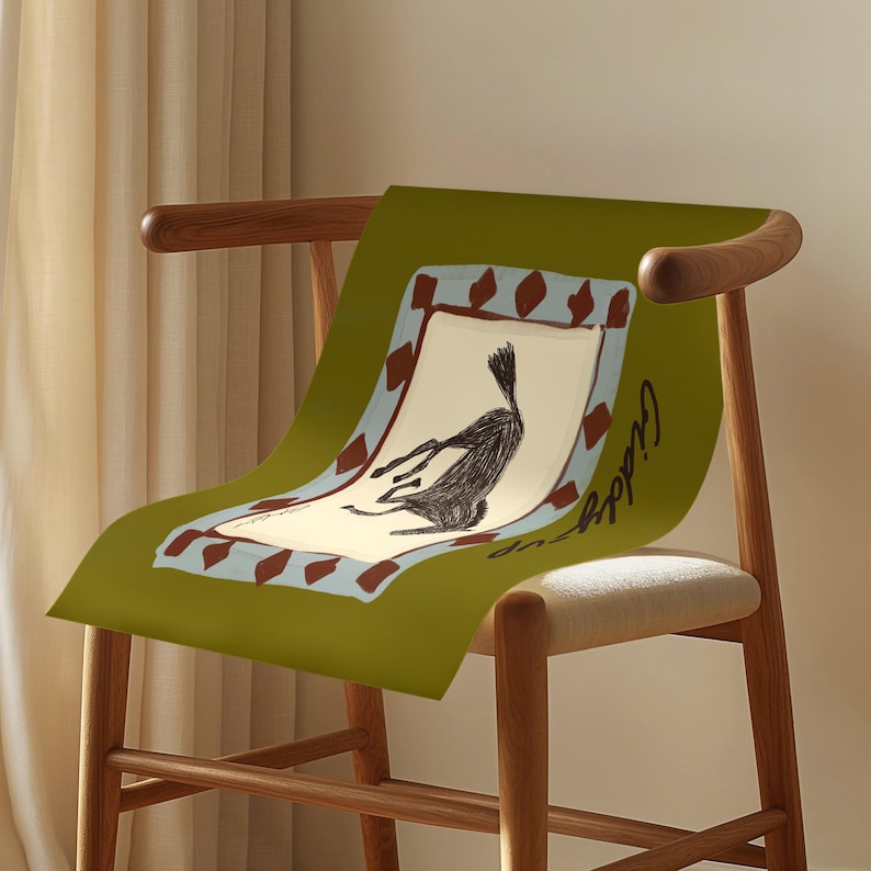 Puede incluir: Un p&oacute;ster verde con una ilustraci&oacute;n caprichosa de una criatura negra, enmarcado con un borde marr&oacute;n y azul, sobre una silla de madera. La palabra "Giddy" est&aacute; escrita en cursiva en el p&oacute;ster.