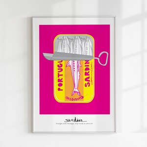 May include: A framed art print featuring a stylized yellow tin of sardines against a vibrant magenta background. The tin shows a silver sardine illustration with the text PORTUGUESE SARDINES and the word sardines with the phrase Straight from Portugal, kept fresh in olive oil.