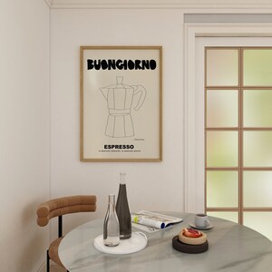 May include: A framed wall art print featuring a black line drawing of a moka pot centered on a beige background. The text BUONGIORNO appears in bold black letters at the top, with ESPRESSO and smaller text printed in black at the bottom of the print.