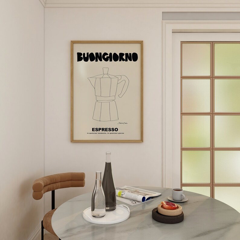 May include: A framed wall art print featuring a black line drawing of a moka pot centered on a beige background. The text BUONGIORNO appears in bold black letters at the top, with ESPRESSO and smaller text printed in black at the bottom of the print.