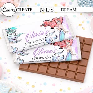 Op de afbeelding: Twee chocoladerepen met verpakkingen met een zeemeerminillustratie en de tekst "Olivia's 5th Birthday". De verpakkingen hebben een turquoise en paars kleurenschema. Naast de verpakte repen ligt een effen bruine chocoladereep.