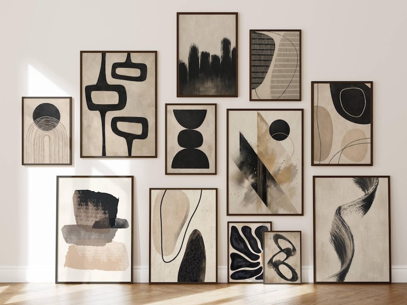 May include: A gallery wall collection of twelve framed art prints featuring abstract compositions in black, beige, and cream. The prints display various geometric shapes, organic forms, brushstrokes, and line art, all enclosed in dark brown frames.