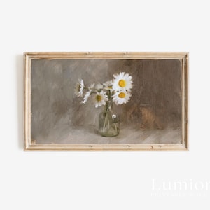 May include: A framed vintage-style print featuring a still life of daisies in a clear glass vase. The daisies have white petals and yellow centers. The background is a muted, neutral color palette. The frame is a light brown color.