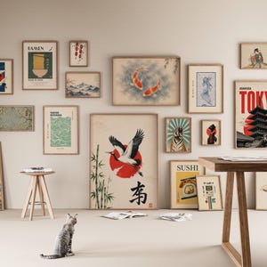 Peut inclure: Un mur de galerie pr&eacute;sentant une collection d'impressions d'art encadr&eacute;es sur le th&egrave;me du Japon, incluant des repr&eacute;sentations de pagode, de carpes ko&iuml;, de grue, de tigre, de ramen et de sushis, dispos&eacute;es sur un mur clair au-dessus d'une table.