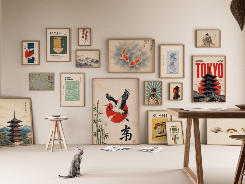Peut inclure: Un mur de galerie pr&eacute;sentant une collection d'impressions d'art encadr&eacute;es sur le th&egrave;me du Japon, incluant des repr&eacute;sentations de pagode, de carpes ko&iuml;, de grue, de tigre, de ramen et de sushis, dispos&eacute;es sur un mur clair au-dessus d'une table.