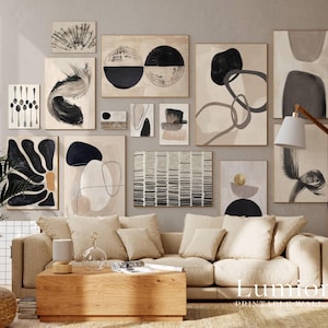 May include: A gallery wall featuring a collection of framed abstract art prints in black, white, and beige tones. The prints display various shapes, lines, and textures, arranged in a grid-like pattern above a beige sofa and wooden coffee table.