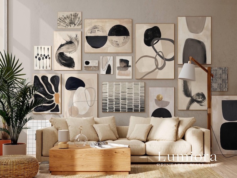 May include: A gallery wall featuring a collection of framed abstract art prints in black, white, and beige tones. The prints display various shapes, lines, and textures, arranged in a grid-like pattern above a beige sofa and wooden coffee table.