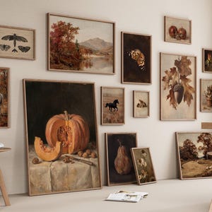 Puede incluir: Una composici&oacute;n de pared de galer&iacute;a con m&uacute;ltiples l&aacute;minas de arte enmarcadas con temas oto&ntilde;ales, incluyendo un bodeg&oacute;n de calabaza, un caballo blanco en un campo, insectos, una pera, bellotas y paisajes, expuestos en una pared clara.