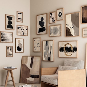 May include: A gallery wall arrangement featuring numerous framed abstract art prints in various sizes. The collection includes black, white, beige, and gold tones with geometric shapes, lines, and organic forms displayed on a light-colored wall.