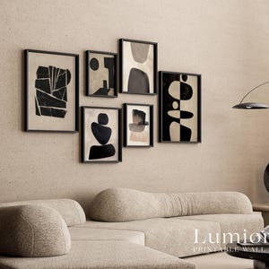 May include: A gallery wall set of six framed prints featuring black and beige abstract shapes and geometric patterns. The collection includes various rectangular frames arranged in a cluster, displaying contrasting dark forms against light backgrounds.