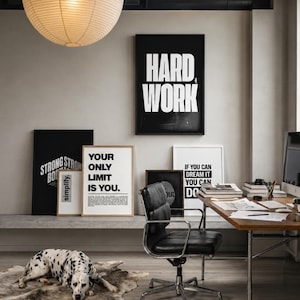 May include: A home office featuring a black framed poster with the text HARD WORK, a white framed poster with the text YOUR ONLY LIMIT IS YOU, and a white framed poster with the text IF YOU CAN DREAM IT YOU CAN DO IT, alongside a black office chair.