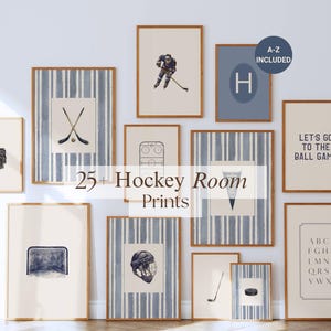 May include: A collection of framed hockey-themed prints. The prints feature hockey equipment, action shots, and text, including "25+ Hockey Room Prints," "Let's Go to the Ball Game," and an alphabet. The frames have a light wood finish.