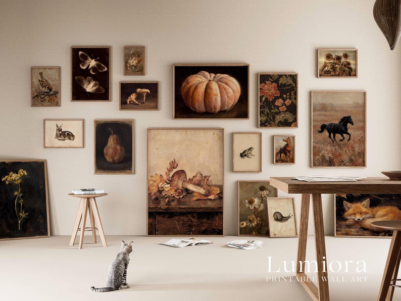 Puede incluir: Una colecci&oacute;n de l&aacute;minas de arte enmarcadas en una pared, con ilustraciones de tem&aacute;tica natural que incluyen una calabaza, una seta, un caballo, un zorro, un caracol, una rana, polillas y elementos bot&aacute;nicos, en un entorno de tonos neutros.