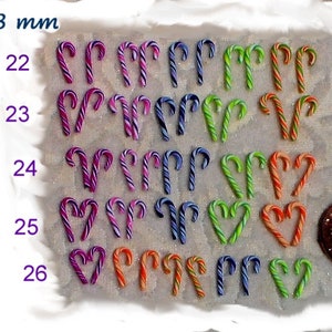 May include: Assortment of candy cane shaped ornaments in various colors, including purple, pink, green, orange, and blue. The ornaments are arranged in rows, with each row labeled with a number from 22 to 26. The text "9-13 mm" is visible at the top of the image.