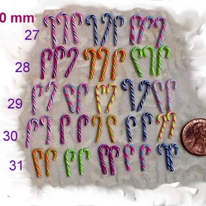 May include: A collection of 20 miniature candy canes in various colors, including pink, purple, blue, green, orange, and yellow. The candy canes are arranged in rows and numbered 27 through 31. A US penny is included for scale, measuring 13-20 mm.