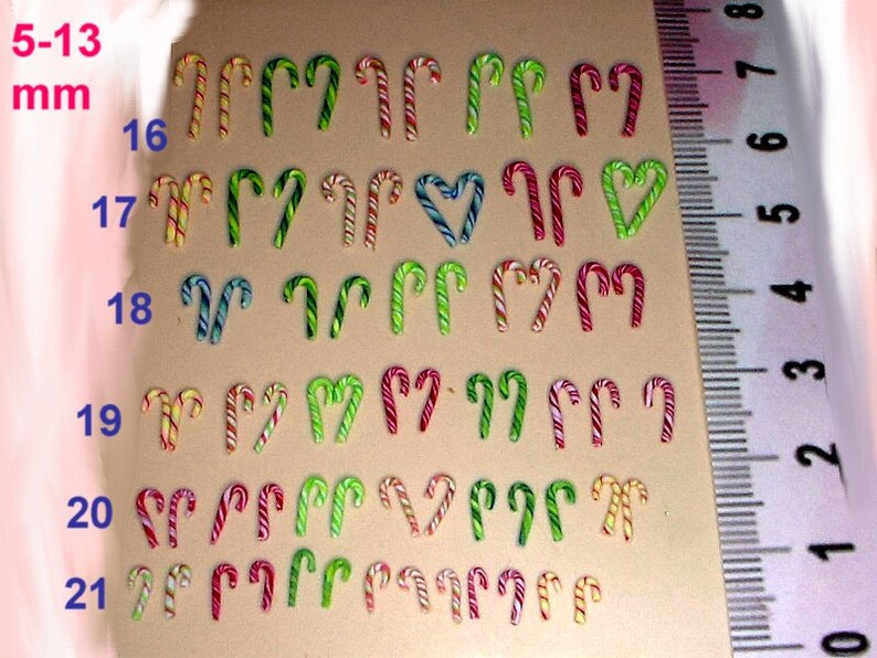 May include: A ruler with measurements in millimeters from 5 to 13, with a row of 11 candy canes in each row, from 16 to 21, with different colors and patterns, including red, white, green, yellow, and blue.