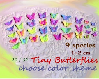 Peut inclure: Une collection de 20 figurines de papillons miniatures colorées, mesurant chacune de 1 à 2 cm. Les papillons sont disposés sur une surface blanche et scintillante. Le texte "9 espèces" et "Petits papillons choisissez le thème de couleur" est visible sur l'image.