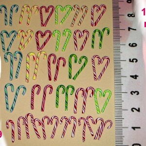 May include: A sheet of 20 candy cane stickers in various colors, including red, green, and white. The stickers are approximately 12-18 mm in size.