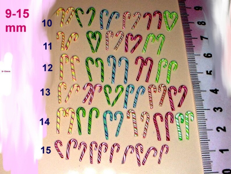 May include: Assortment of candy cane shaped charms in various colors and patterns, ranging in size from 9 to 15 millimeters. The charms are arranged in rows by size, with a ruler in the background for reference.