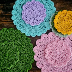Peut inclure: Ensemble de dessous de verre crochetés à la main, aux couleurs variées : vert, rose, jaune et bleu. Chaque dessous de verre présente un bord festonné et un centre en spirale, parfait pour protéger les surfaces.
