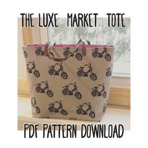 May include: A beige tote bag with a brown leather handle and a black and white pattern of vintage motorcycles. The bag has the text "THE LUXE MARKET TOTE" printed on the top and "PDF PATTERN DOWNLOAD" printed on the bottom.