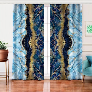 Puede incluir: Un par de cortinas con un diseño de ágata azul y dorado. Las cortinas presentan un efecto marmolado con tonos de azul, marino y dorado. El diseño es simétrico, con un centro azul oscuro y vetas doradas.