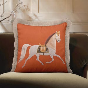 Whether you're a dressage rider or a casual fan, this Horse Art Pillow belongs in your home. It celebrates the beauty and strength of the horse through detailed illustration and elegant design. The fringe detailing mimics the grace of a horse's mane, adding a thematic touch to the pillow's edges. It’s a thoughtful and stylish gift for trainers, riders, or anyone with an equestrian heart.