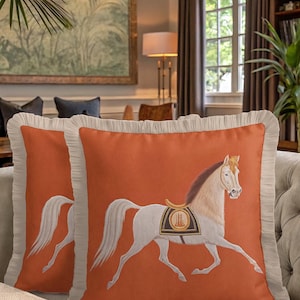 Combine the free-spirited vibe of bohemian decor with the elegance of luxury textiles. Our Fringed Horse Cover features a unique mix of tassels and classical imagery. The vibrant orange hue provides a bold contrast to the cream-colored fringes, making it a standout piece for boho-chic interiors. Elevate your space with this unique blend of patterns and textures.