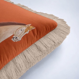 Clean lines meet traditional art in our Tasseled Horse Pillow Cover. While the horse illustration is classical, the minimalist fringe and bold orange palette make it suitable for modern apartments. It creates a perfect balance between old-world prestige and contemporary style. Place it on a neutral-colored chair to let the vibrant design and unique textures speak for themselves.