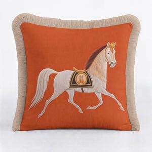 Equestrian Elegance: Discover the perfect blend of art and comfort with our Horse Throw Pillow Cover. Featuring a majestic white horse on a vibrant orange backdrop, this piece captures the spirit of equestrian grace. The elegant fringe trim adds a vintage luxury feel, making it an ideal accent for farmhouse or classic interiors. Handcrafted with premium fabric, it’s a must-have for horse lovers looking to elevate their living room decor with a unique, artistic touch.
