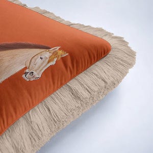 Our fringed covers celebrate the beauty of handmade-style textiles. The tassels are carefully applied to ensure a symmetrical and elegant finish. This attention to detail reflects the quality found in boutique home stores. By choosing this horse-themed pillow, you’re supporting unique designs and bringing a touch of artisan soul into your living space.