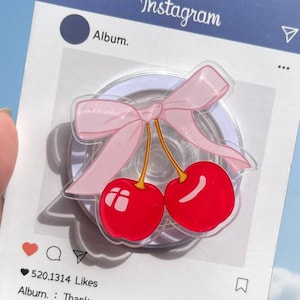 May include: A decorative acrylic cherry charm with a pink bow, set against a mock Instagram post design. The post includes the Instagram logo, a heart icon, and the text "Thank you for liking it".