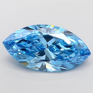 May include: A marquise-cut gemstone in a bright, light blue colour. The facets of the gem reflect light, creating a sparkling effect. The gemstone is set against a plain white background.