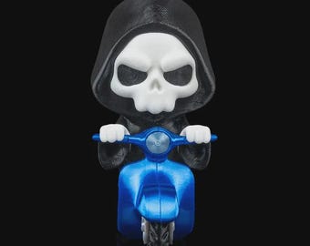 May include: A figurine of the Grim Reaper riding a blue scooter. The Reaper has a white skull face and is wearing a black hooded cloak. The scooter is a vibrant blue color.