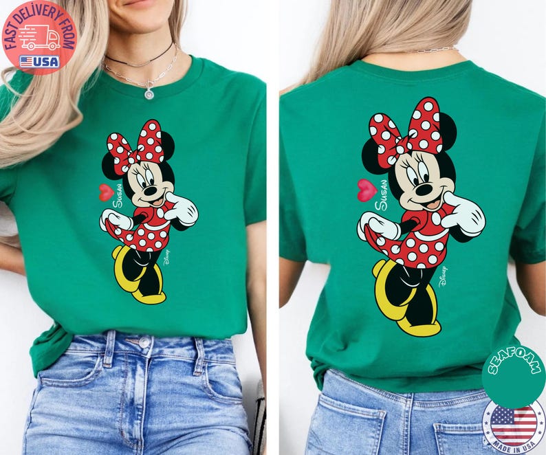May include: A teal green t-shirt with a Minnie Mouse design on the front and back. Minnie is depicted in a red polka dot dress and bow, with yellow shoes. The name "Susan" is written on the shirt.