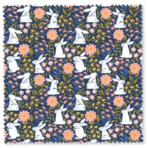 Könnte beinhalten: Stoffmuster mit einem sich wiederholenden Muster aus weißen Kaninchen, rosa Gänseblümchen und gelben Blumen auf marineblauem Hintergrund. Das Design umfasst grüne und blaue Blätter und schafft ein Frühlings- oder Osterthema.