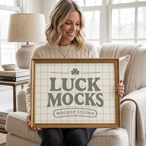 Può includere: Un'opera d'arte incorniciata con la scritta "LUCK MOCKS" in un carattere serif, con un simbolo di trifoglio. L'opera d'arte è in una cornice dorata e ha uno sfondo a griglia. Le parole "Mockup Studio" sono sotto il testo principale.