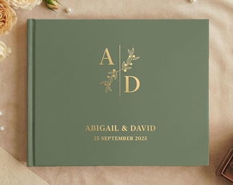 Puede incluir: Un libro de visitas de tapa dura en color verde salvia con letras en lámina dorada. La portada muestra las iniciales A y D separadas por una línea vertical con una rama botánica, seguidas de los nombres Abigail & David y la fecha 25 de septiembre de 2025.