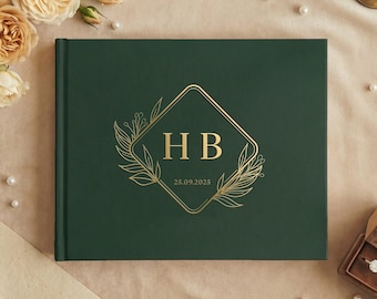 Può includere: Un libro degli ospiti di nozze verde scuro con scritte dorate e un design floreale decorativo. Il libro presenta le iniziali "HB" e la data "25.09.2025". Il libro è circondato da perle, fiori e un portagioie.