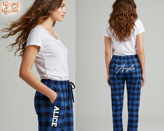 May include: A woman wearing a white t-shirt and blue and black plaid pajama pants. The pajama pants have the name "Alice" printed vertically on the left leg and the name "Angela" printed on the back. The pajama pants have a drawstring.