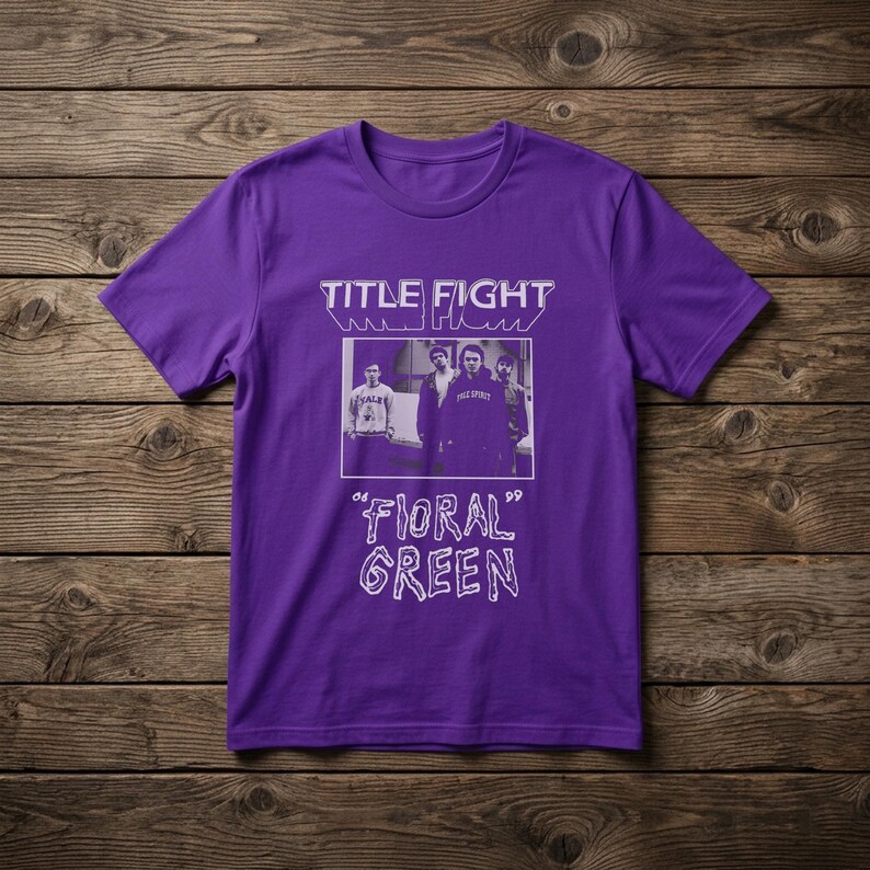 Puede incluir: Una camiseta morada de manga corta con un estampado gr&aacute;fico en blanco. El dise&ntilde;o incluye el texto "TITLE FIGHT" en la parte superior, una fotograf&iacute;a rectangular en blanco y negro de cuatro personas en el centro y el texto "FLORAL GREEN" debajo.