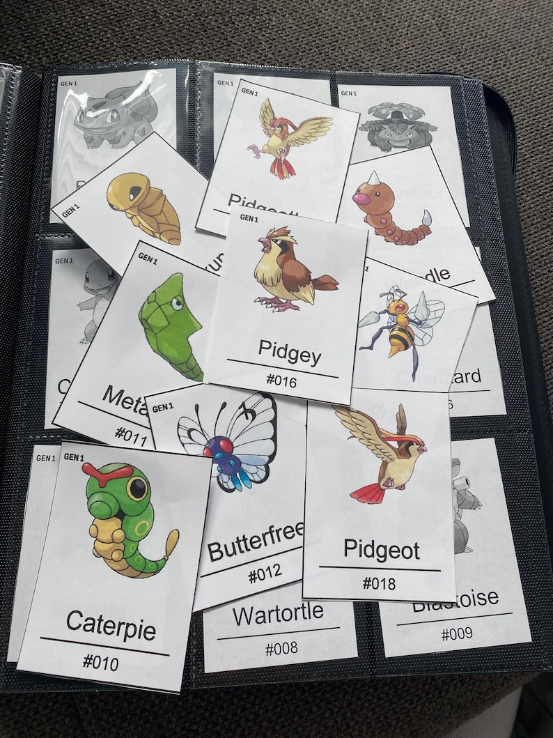 Pu&ograve; includere: Una collezione di carte collezionabili rettangolari con illustrazioni colorate di varie creature, ognuna etichettata con un nome e un numero. Le carte sono disposte in una custodia trasparente per raccoglitore, mostrando personaggi come Caterpie, Pidgey e Pidgeot.
