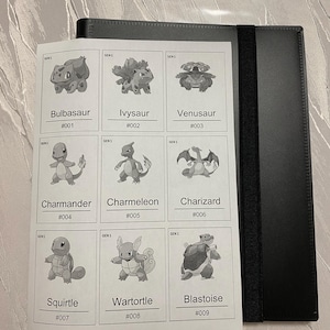 Pu&ograve; includere: Un raccoglitore nero con una fascia elastica contiene un foglio bianco con nove illustrazioni in bianco e nero di personaggi Pokemon etichettati Bulbasaur #001, Ivysaur #002, Venusaur #003, Charmander #004, Charmeleon #005, Charizard #006, Squirtle #007, Wartortle #008 e Blastoise #009.