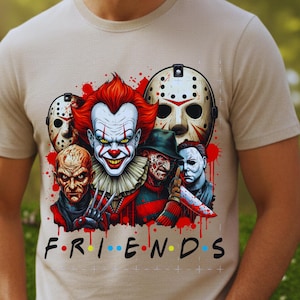 May include: Beige t-shirt featuring a graphic of horror movie characters, including a clown, a masked figure, and others. The word "FRIENDS" is written in the style of the TV show logo. Red blood splatter accents the design.