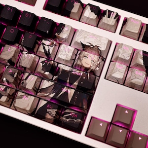 Könnte beinhalten: Eine mechanische Custom-Tastatur mit Tastenkappen im Anime-Stil. Die Tastenkappen haben ein weißes und schwarzes Farbschema mit rosa Akzenten. Die Tastatur hat einen silbernen Rahmen und eine rosa Hintergrundbeleuchtung.
