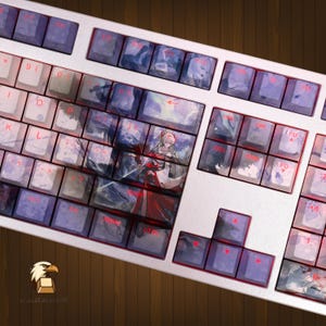May include: A white mechanical keyboard featuring custom keycaps with a printed anime-style illustration of a character in a red and white outfit. The keys display various symbols and letters, with some keys showing a continuous landscape scene.