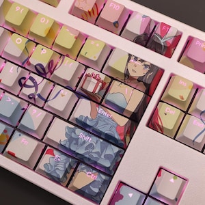 Könnte beinhalten: Eine individuelle mechanische Tastatur mit Tastenkappen mit Anime-Illustrationen. Die Tastenkappen sind eine Mischung aus Pastellfarben, mit Illustrationen einer Frau, die ein Geschenk hält. Die Tastatur hat einen weißen Rahmen und eine rosa Hintergrundbeleuchtung.
