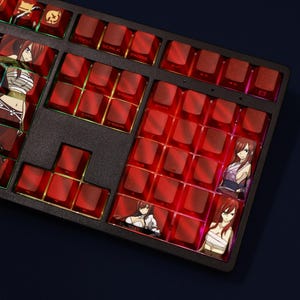 May include: A black mechanical keyboard with red keycaps. Some keycaps feature anime character illustrations. The keyboard has a standard layout with function keys and a number pad. The keycaps are translucent, allowing the internal lighting to shine through.