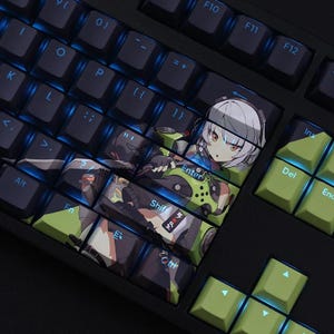 May include: Black mechanical keyboard with blue backlighting. The Enter, Shift, and other keys feature anime-style artwork. Green keys are on the right side. The keyboard is designed for gaming or custom builds.